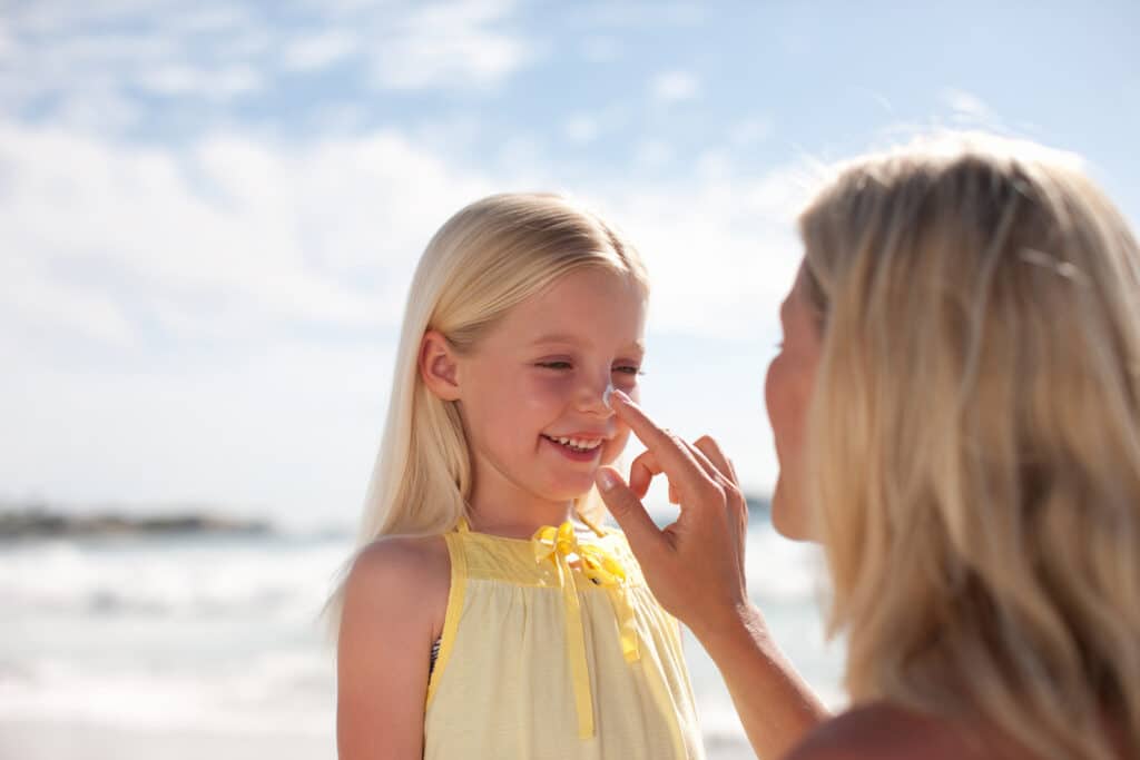Mother applying sunscreen to daughter - Skincare Tips