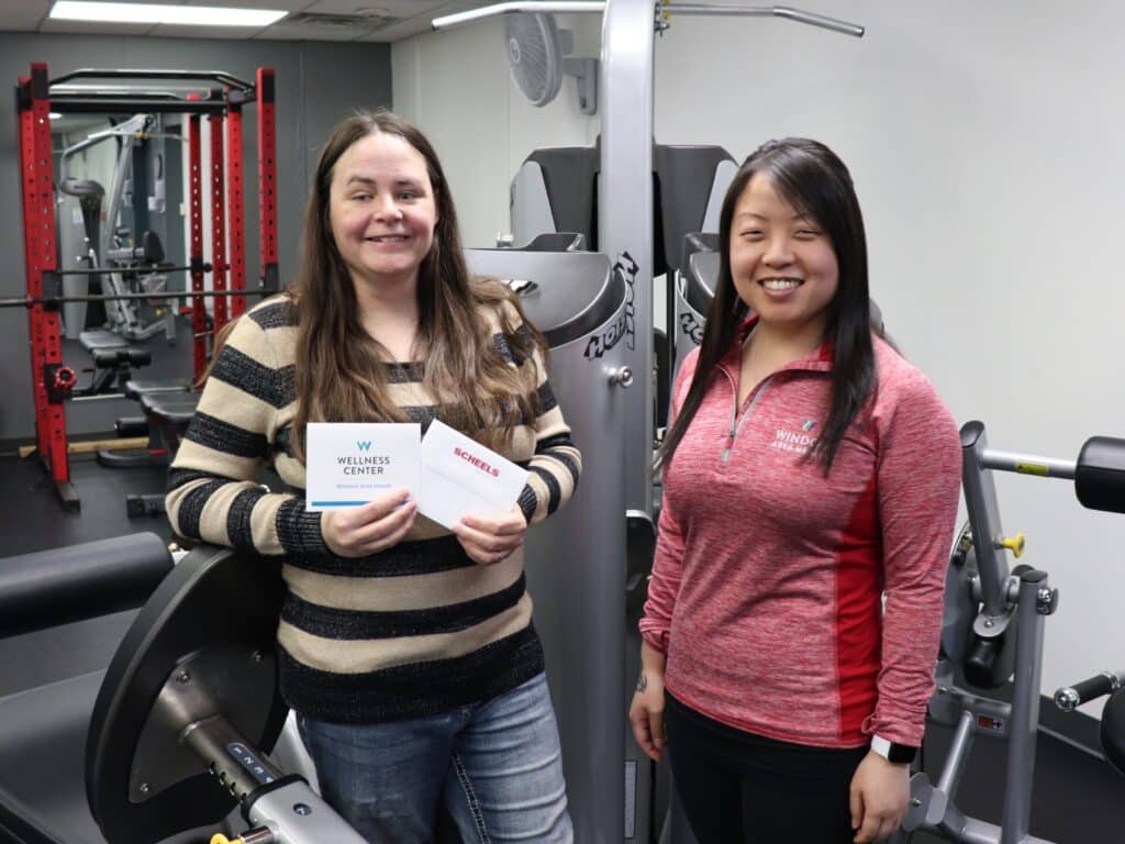 2023 Weight Loss Challenge Community Winner, Tammy Meyer, with her prizes: a $100 gift card to Scheels and a 3 Month Membership to the Wellness Center with Lindsey Englar, Wellness Center Supervisor